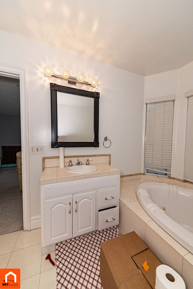 Master bathroom before renovation - dated vanity and corner tub
